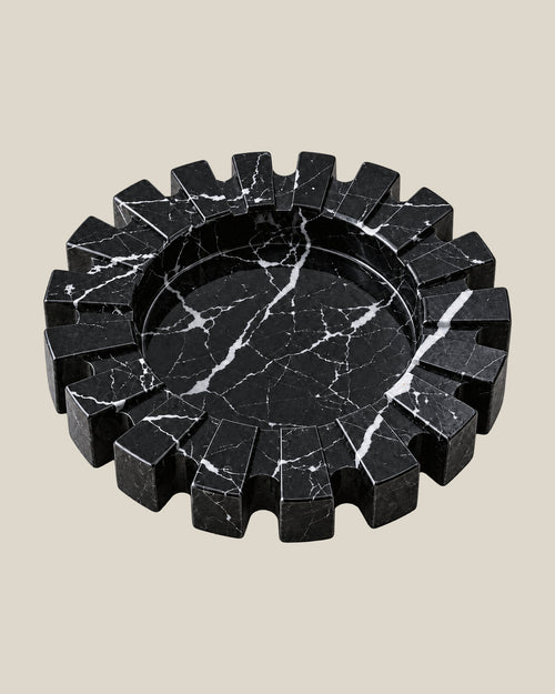 Aston Ash Tray in Spanish Black Marble, three-quarter view showing the carved notched rim and recessed centre.