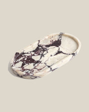 ATOMS OVAL Tray Calacatta Viola marble, angled view on a BONE background