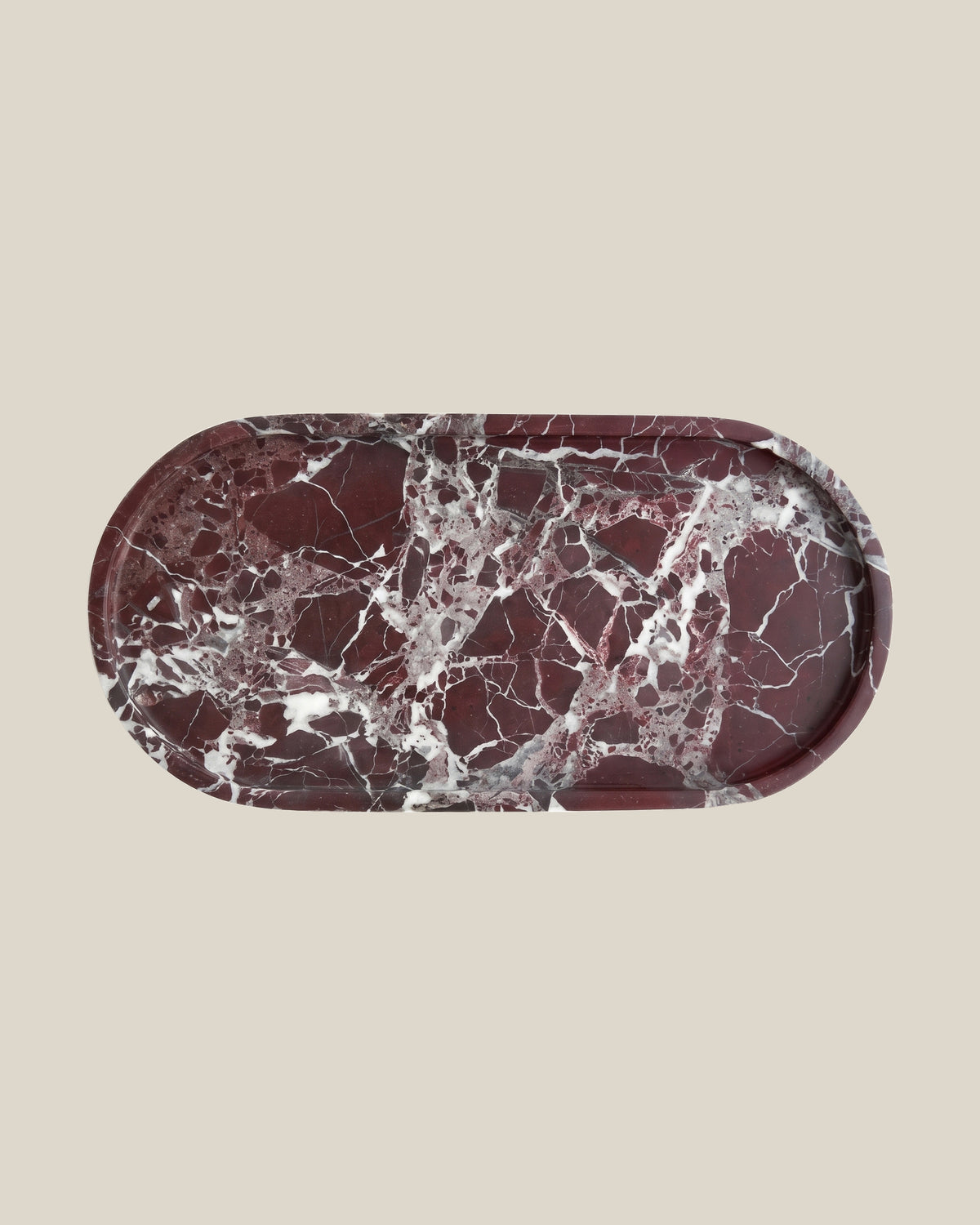 ATOMS OVAL Tray Rosso Levante marble, top view on a BONE background