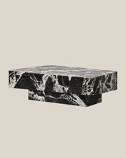 BUTTER coffee table by CARVINGS in Grand Antique Black Marble, on a BONE background, left view.
