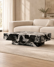 BUTTER coffee table by CARVINGS in Grand Antique Black Marble, in a styled living room, left view.