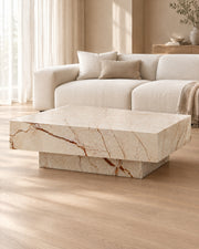 BUTTER coffee table by CARVINGS in Sofita Beige Marble, in a styled living room, right view.