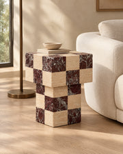 BUTTER side table by CARVINGS in Chequered Rosso Levante & Travertine Beige, in a styled living room, left view.