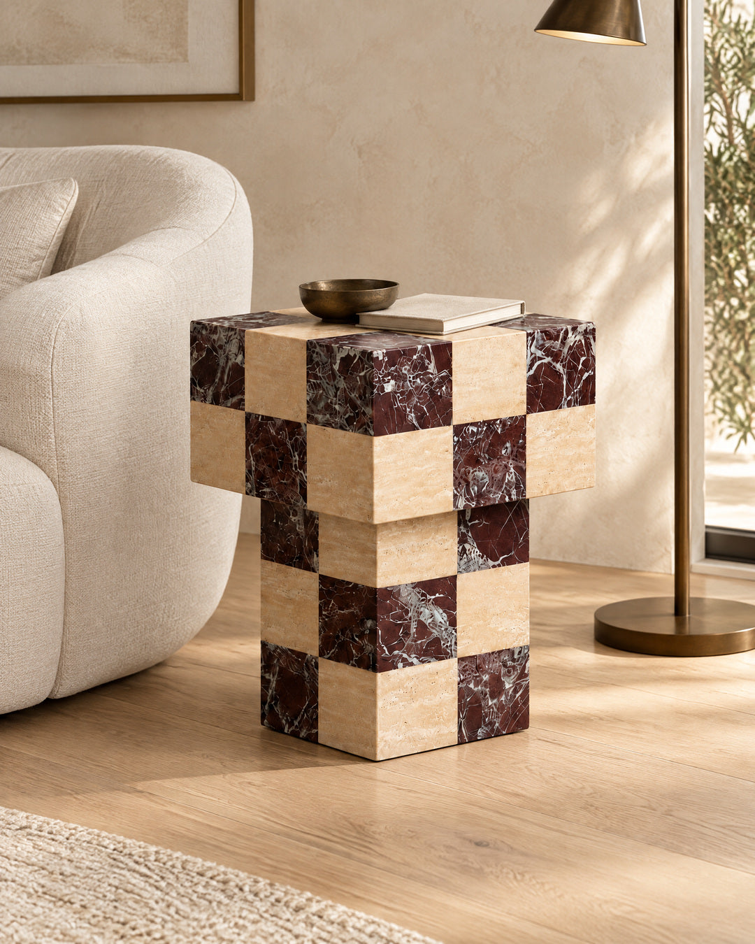 BUTTER side table by CARVINGS in Chequered Rosso Levante & Travertine Beige, in a styled living room, right view.