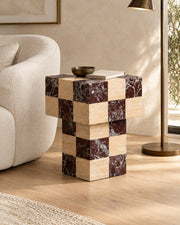 BUTTER side table by CARVINGS in Chequered Rosso Levante & Travertine Beige, in a styled living room, right view.