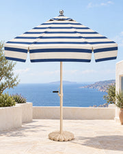 Riviera fully striped navy and ivory umbrella on a Mediterranean terrace