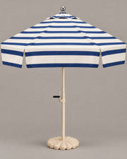 Riviera fully striped navy and ivory umbrella in a warm grey studio