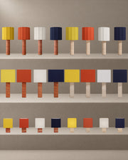 All 24 Roma Table Lamp variants together in the studio hero. Large Faceted and Large Square at 85 cm; Small Square at 44 cm. Both travertine bases and all four chapeau colours.