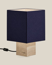 Roma Table Lamp, Small Square, Travertine Beige + Dark Blue, on a bone background.